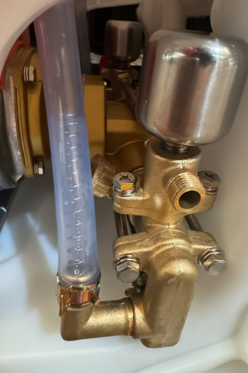 4 stroke power sprayer pump Close-up of a brass valve with a clear tube attached, likely part of a machine or equipment.